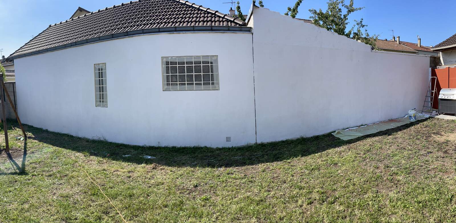 The white gable wall of the house before the mural project started